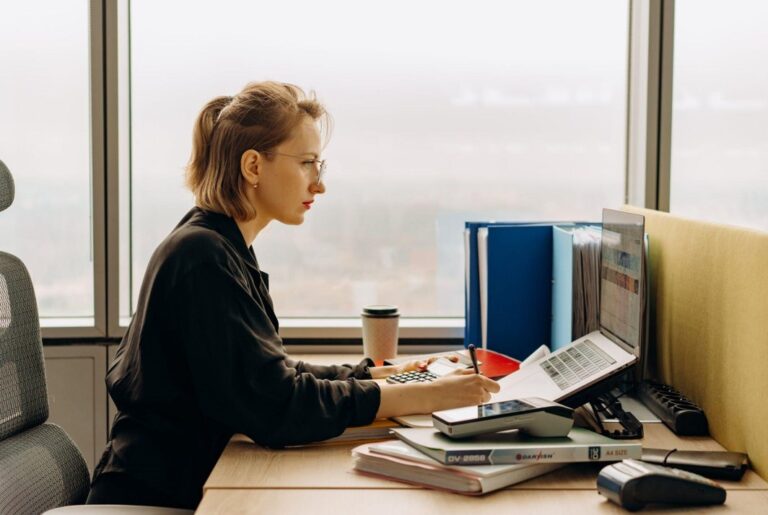 side view woman laptop working calculator accounting