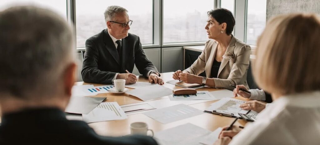 boardroom meeting with papers contracts men and women