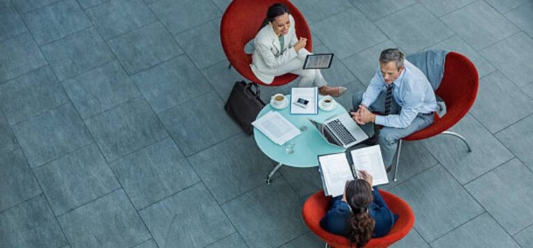 man two women meeting with laptop table and paper in red chairs