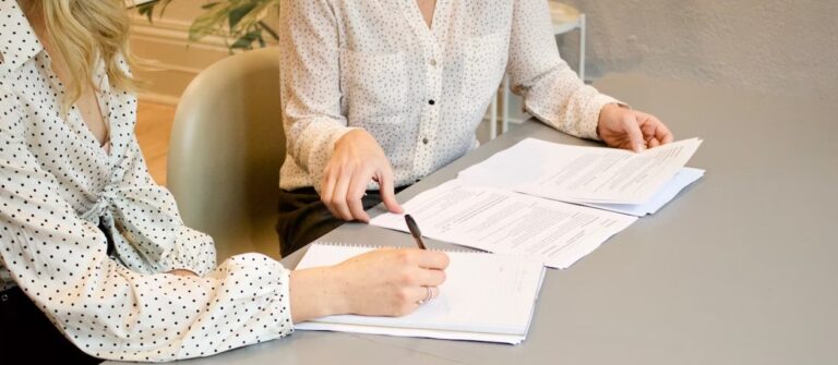 signing documents and making notes two women contract