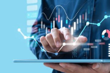 hand on tablet with graphs tables charts