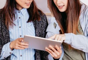 two university women on tablet