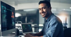 man on computer smiling at camera