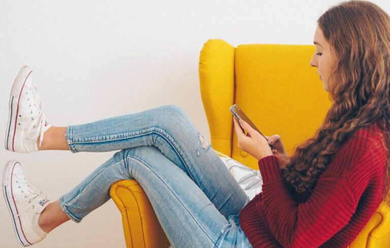 women in chair looking at phone