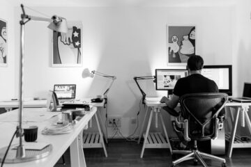 man sitting in front of computer in white room