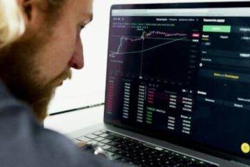 man looking at forex charts on laptop