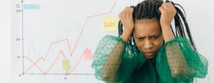 women pulling at hair with profit and loss chart